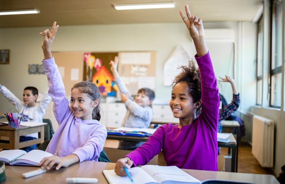 Pupils answering questions in a busy classroom