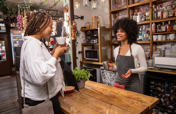 A cafe owner serving coffee with a smile