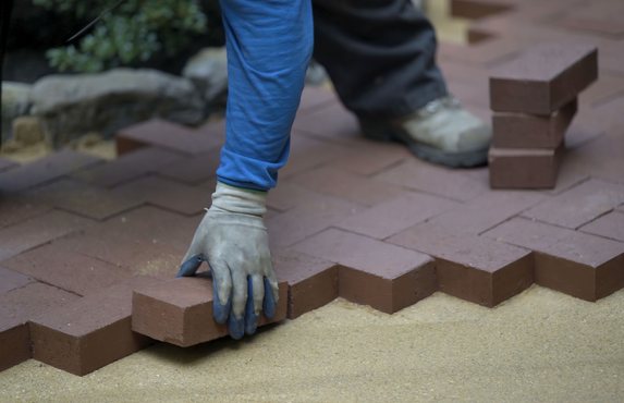Laying brick pavers in a herringbone patio